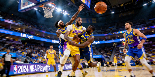 NBA季后赛湖人队对阵勇士队的比赛现场，球员激烈对抗